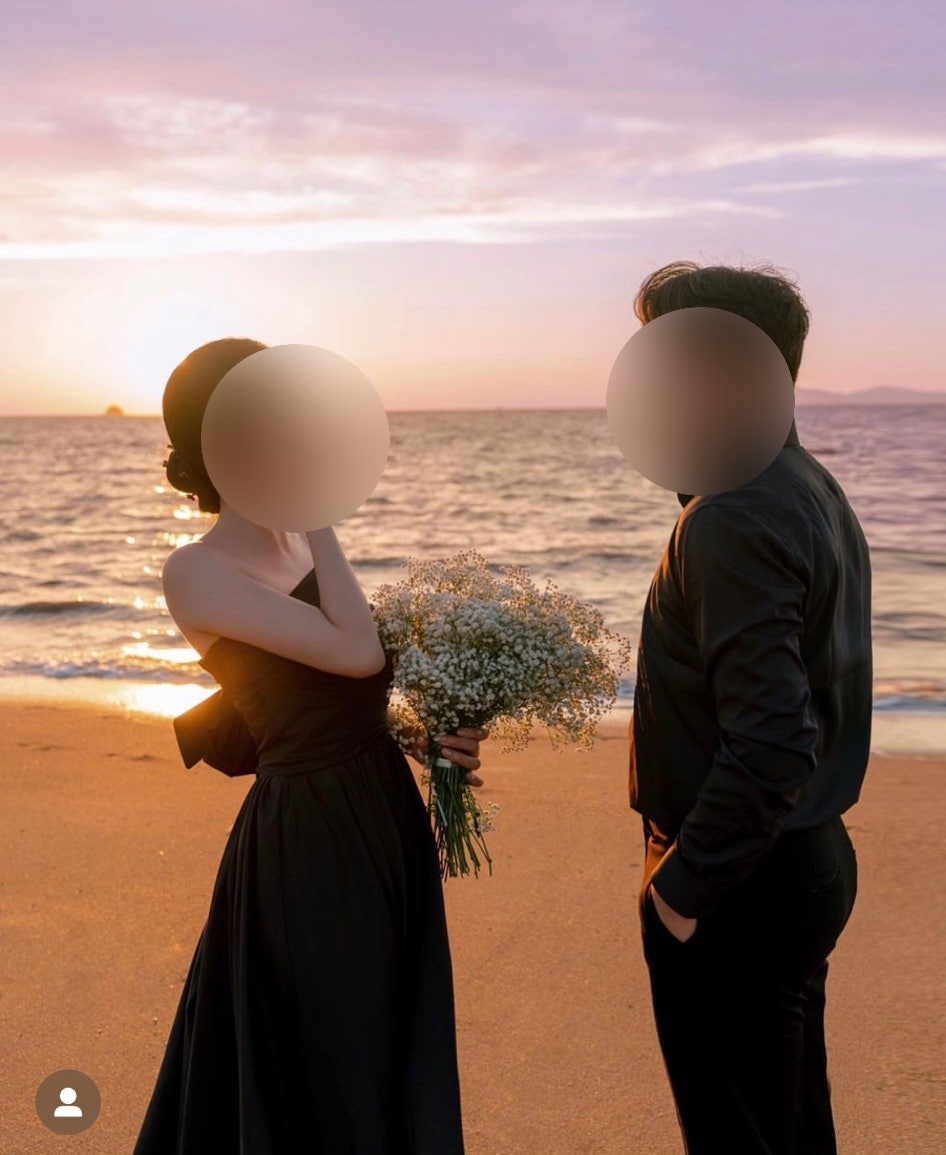 해 질 녘 바닷가에서 블랙 원피스 신부가 안개꽃 부케를 들고 블랙 셔츠 신랑과 마주 선 컷이에요. 블랙 룩에 안개꽃을 매치하는 방법을 참고하기 좋아요.