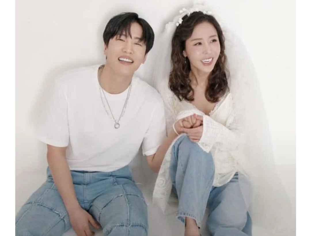 흰 티와 청바지 신랑 옆에 베일과 청바지 차림 신부가 바닥에 앉아 웃는 컷이에요. 드레스 대신 청바지에 베일만 얹는 조합을 보여줘요.
