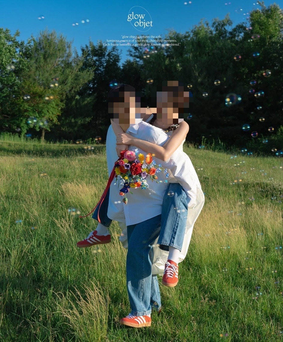 흰 셔츠와 청바지 차림으로 신부를 업고 비눗방울 속에서 웃는 장면이에요. 알록달록한 부케와 빨간 운동화가 포인트예요.